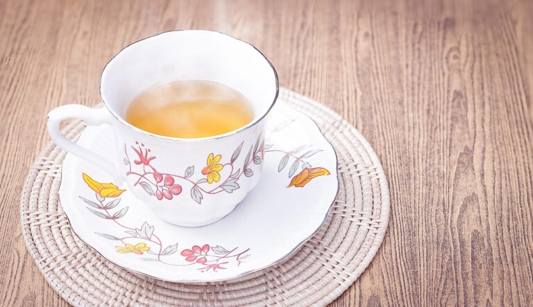 Tisana depurativa per ridurre il gonfiore addominale, servita in una tazza con erbe fresche.