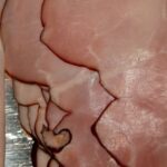 Fetta di prosciutto cotto con evidenziata l'etichetta contenente informazioni sui nitriti.