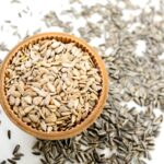 Semi di girasole con focus su vitamina E, simbolo di bellezza e giovinezza per la pelle.