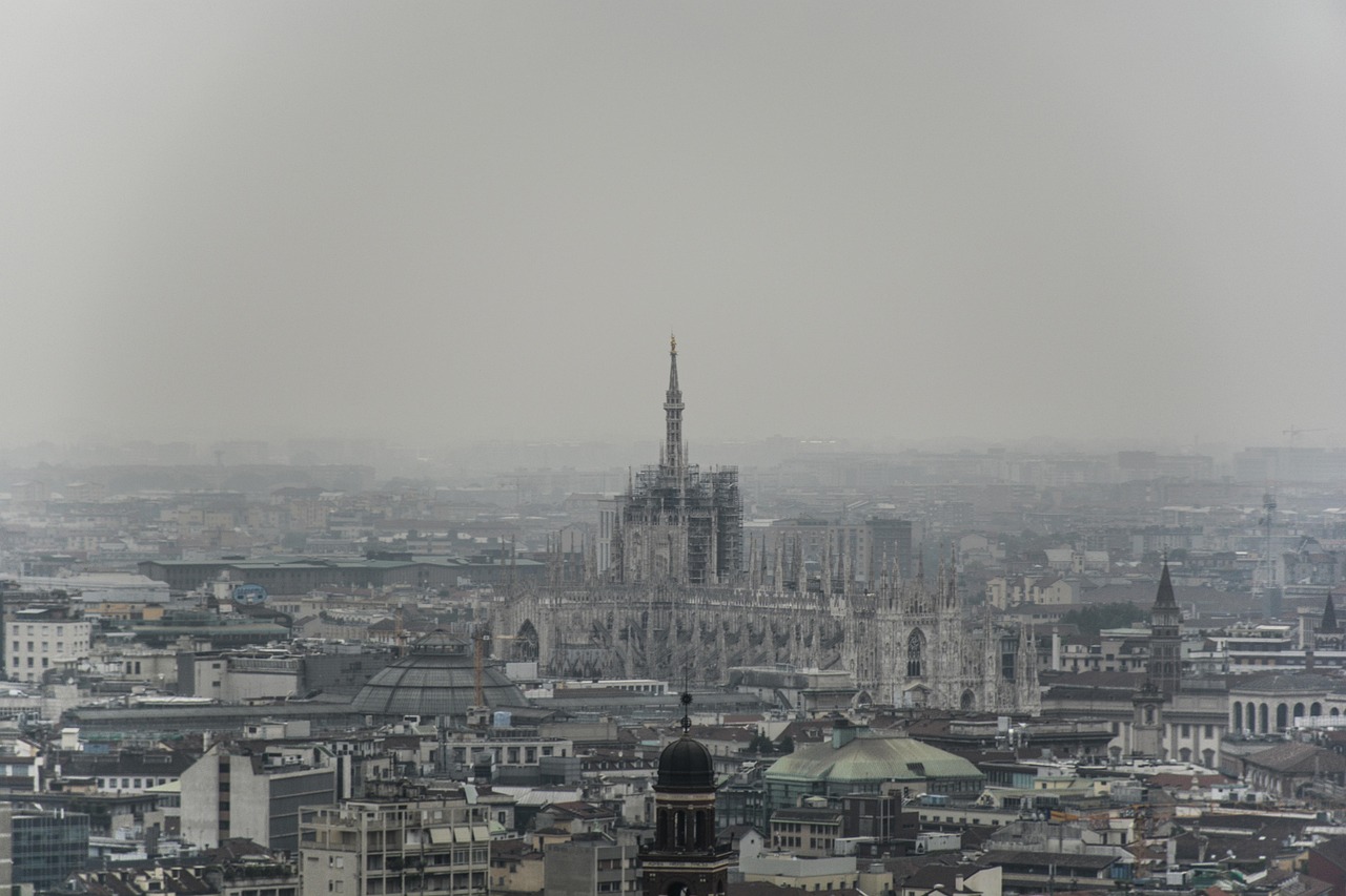 Panorama di Milano in inverno con pioggia, evidenziando monumenti e attività al coperto.
